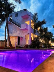 a house with a swimming pool with purple lighting at Serenity beach side in Pondicherry