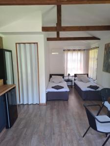 a living room with two beds and a tv at dom & weranda in Szczęsne