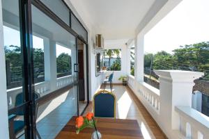 a balcony with a table and chairs and windows at Diani Luxe villa 1bdr B, 600m from the beach in Galu