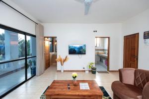 a living room with a couch and a table at Diani Luxe villa 1bdr B, 600m from the beach in Galu +21 photos