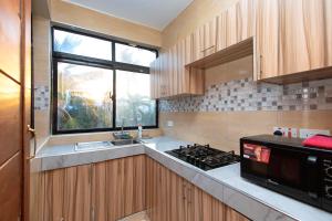 a kitchen with a stove and a sink and a window at Diani Luxe villa 1bdr B, 600m from the beach in Galu
