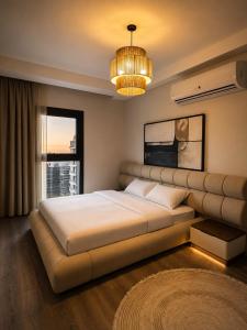 a bedroom with a large bed and a large window at ZED Towers City View Apartment in Sheikh Zayed