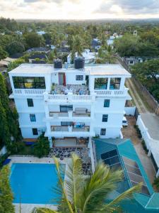an aerial view of a white building with a swimming pool at Diani Luxe villa 1bdr B, 600m from the beach in Galu