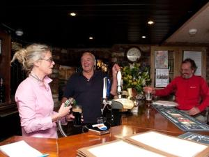 a group of people standing at a bar at The Boot and Shoe in Greystoke