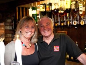 a man and a woman standing in a bar at The Boot and Shoe in Greystoke
