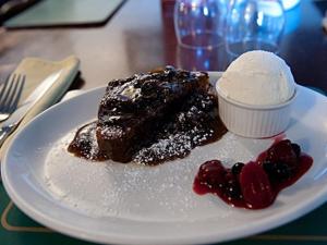 a white plate with a piece of cake and ice cream at The Boot and Shoe in Greystoke