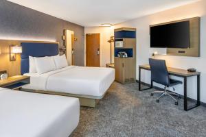 a hotel room with a bed and a desk and a tv at Comfort Inn in North Bay