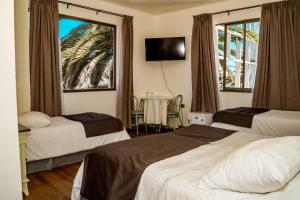 a hotel room with two beds and a window at Hotel Cano in Iquique +26 photos