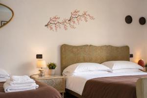 a bedroom with two beds and a tree on the wall at Archivio 32 in Caserta
