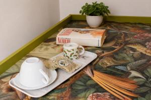 a table with a tea set and a book at Archivio 32 in Caserta +43 photos