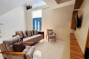 a living room with a couch and a chair at Abaíra Serra Azul Suítes 02 - Centro in Petrolina