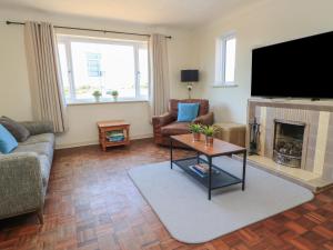 a living room with a fireplace and a flat screen tv at Bayview Cottage in Bournemouth