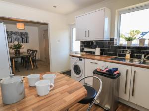 a kitchen with a wooden table in a kitchen at Bayview Cottage in Bournemouth