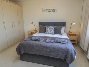 a bedroom with a large bed with a gray blanket at Bayview Cottage in Bournemouth