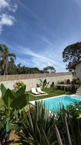 a swimming pool with two lounge chairs in a yard at EcoRefúgio Verde - iUna in Ibiúna