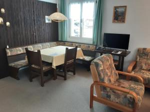a dining room with a table and chairs and a television at Ferienwohnungen Chesa Clois 24 in Lenzerheide