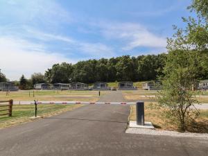 a road with a barrier on it in a field at The Pines 3 Bedrooms in Northwich +1 photo