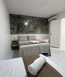 a bedroom with two beds and a large painting on the wall at Abaíra Serra Azul Lofts 1 - Orla - Centro in Petrolina