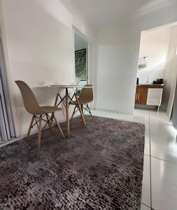 a dining room with a table and two chairs at Abaíra Serra Azul Lofts 1 - Orla - Centro in Petrolina