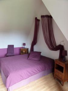 Saint-LéonardにあるGite des galetsのベッドルーム1室(紫色のベッド1台、ナイトスタンド2台付)