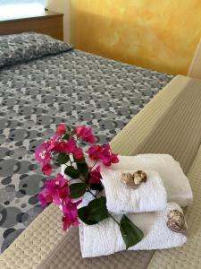 a cat sleeping in a towel on a bed at Villette Isabella in Parghelia