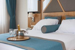 a hotel room with two beds and a tray with wine glasses at Graf Victor Hotel - All Inclusive Non Alcoholic Drinks in Çamyolu