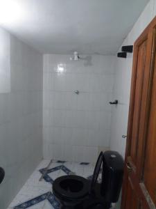 a bathroom with a toilet and a tiled floor at Ecolodge Amanecer in Comunidad Yumani