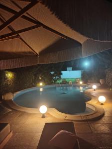 a swimming pool at night with lights and a screen at Luxury Villas Chrysa Private Pool & Spa in Nafplio
