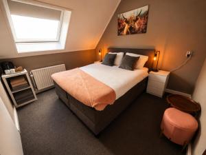a bedroom with a large bed and a window at Hotel Restaurant 't Ronde Loegh in Winschoten