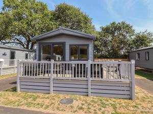 a tiny house with a white fence at The Oaks 2 Bedrooms in Northwich