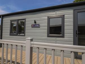 a grey caravan with windows and a fence at The Oaks 2 Bedrooms in Northwich