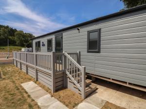 a gray trailer with a ramp and a porch at The Oaks 3 Bedrooms in Northwich