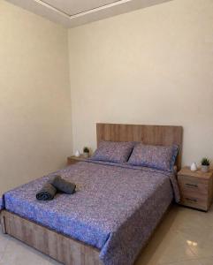 a bedroom with a large bed with a wooden headboard at Luxury Apartment Elevator FIBER WIFI in Oujda
