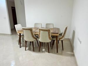 a dining room table with six chairs around it at Luxury Apartment Elevator FIBER WIFI in Oujda