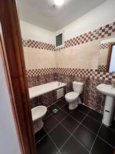 a bathroom with two toilets and a tub and a sink at Luxury Apartment Elevator FIBER WIFI in Oujda