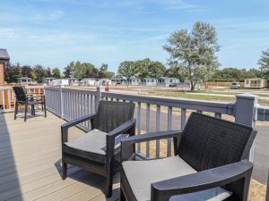 a deck with two chairs and a table and chairs at Cedar Lodge 3 Bedrooms with hot tub in Northwich