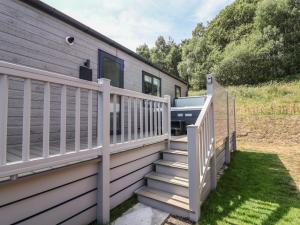 a house with a white fence and a staircase at Cedar Lodge 2 Bedrooms with hot tub in Northwich