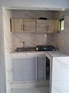 a small kitchen with a sink and a stove at Cabañas Calipso # 7 in Coveñas