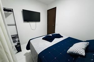 a bedroom with a bed and a tv on the wall at Abaíra Serra Azul Loft 6 - Orla - Centro in Petrolina
