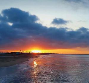 a sunset on a beach with the sun setting at Cabañas Calipso # 7 in Coveñas +3 photos