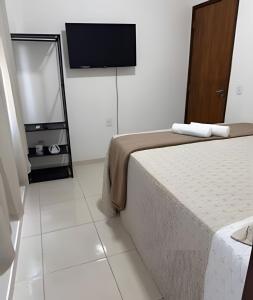 a bedroom with a bed and a flat screen tv at Abaíra Serra Azul Loft 5 - Orla - Centro in Petrolina