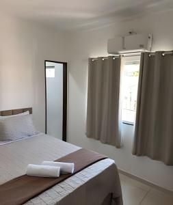 a bedroom with a bed and a window with curtains at Abaíra Serra Azul Loft 5 - Orla - Centro in Petrolina