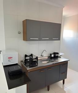 a kitchen with a sink and a microwave at Abaíra Serra Azul Loft 5 - Orla - Centro in Petrolina