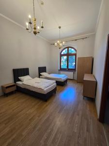 a large room with two beds and a chandelier at Willa Carcassonne in Paczków +17 photos