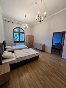 a large room with two beds and a chandelier at Willa Carcassonne in Paczków