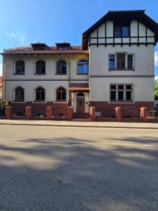 a large white house on the side of a street at Willa Carcassonne in Paczków