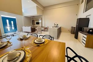 a dining room with a table and a kitchen at Abaíra Serra Azul Suítes 04 - Centro in Petrolina