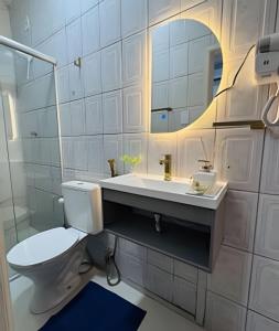 a bathroom with a toilet and a sink and a mirror at Abaíra Serra Azul Suítes 04 - Centro in Petrolina