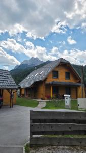 a wooden house with mountains in the background at Apartment Jeršin in Rateče