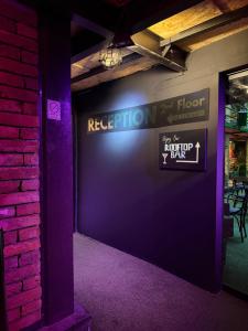 a room with a purple wall with a sign on it at Chillout Hostel Zagreb in Zagreb